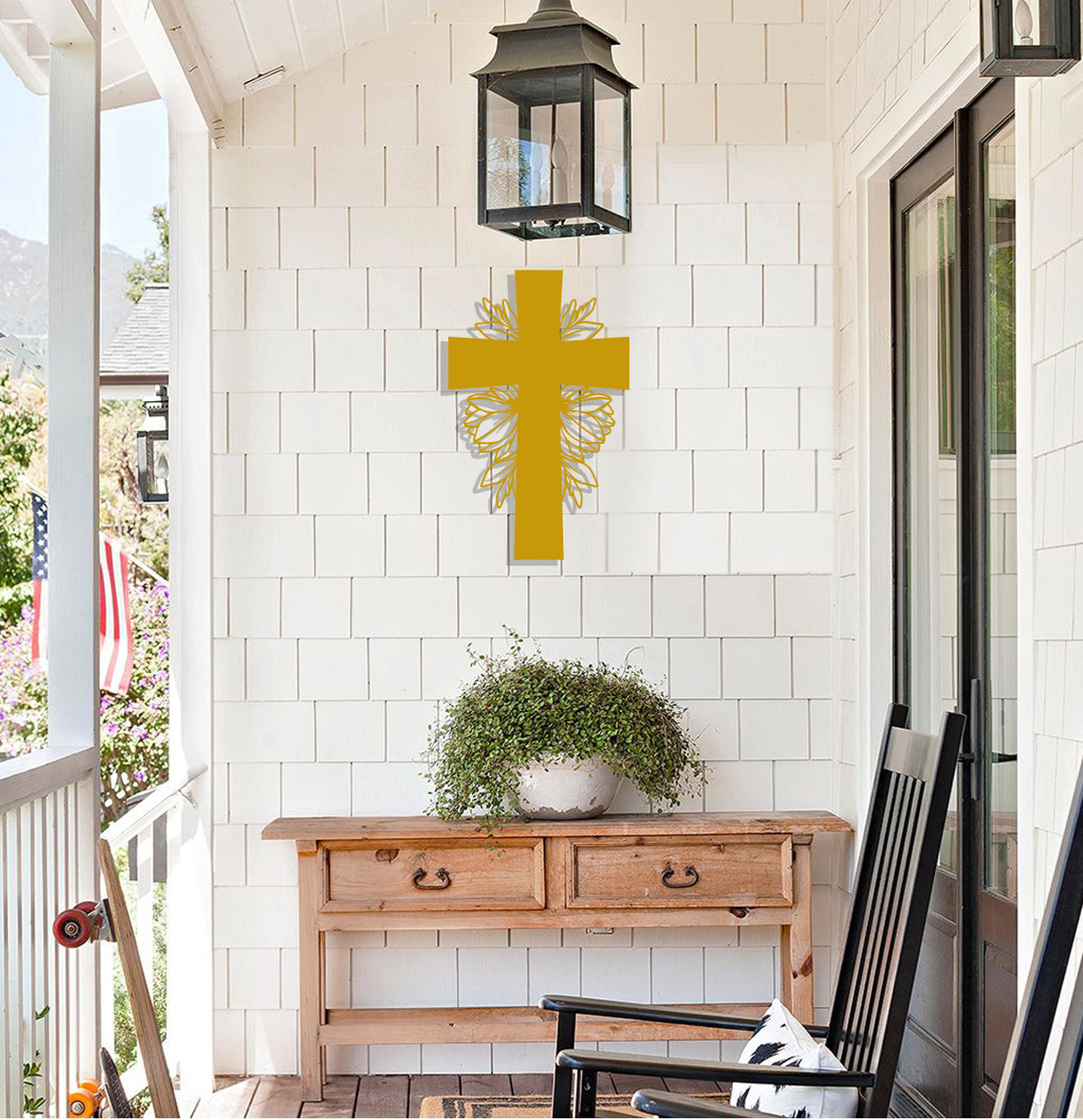 a yellow cross hanging on the wall of a porch