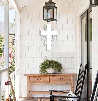 a porch with a wooden table and a cross on the wall